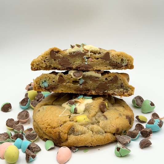 Stack of chocolate chip cookies with candy pieces on a white background