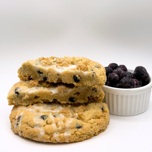 Stack of cookies with a bowl of blueberries on a white background